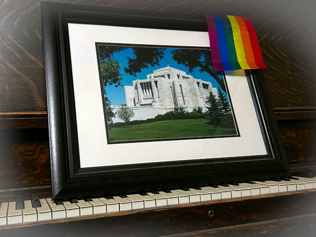 A Picture of a Framed Photo of the Cardston Alberta Temple with a small pride flag representing change can happen anywhere..