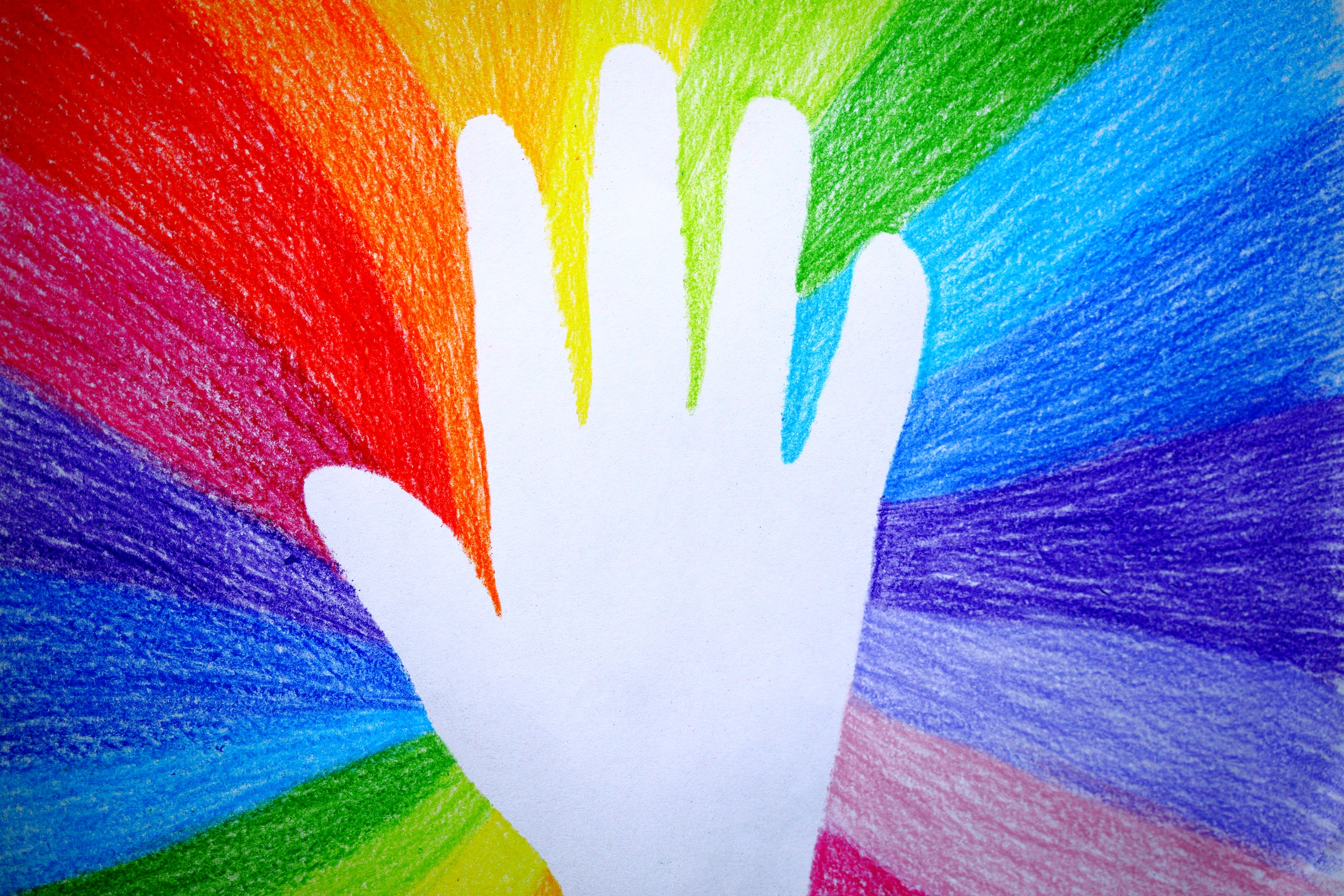 A white traced hand with rays of rainbow colours coming out from behind, representing crisis and suicide prevention resources.