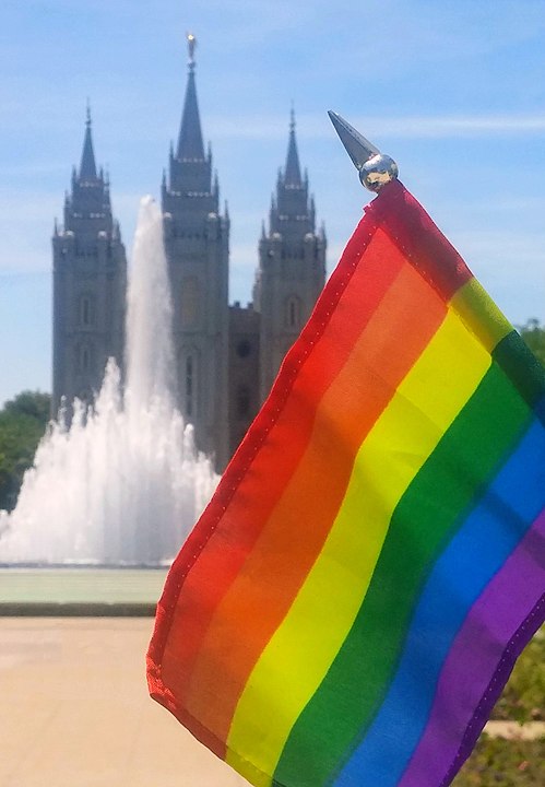 A gay flag with an LDS temple seen in the background.