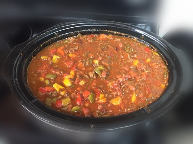 A crockpot full of Spicy Summer Tomato Chili with Bacon and Peppers..