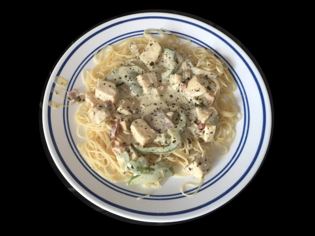 A steaming plate of creamy chicken bacon pesto noodles.